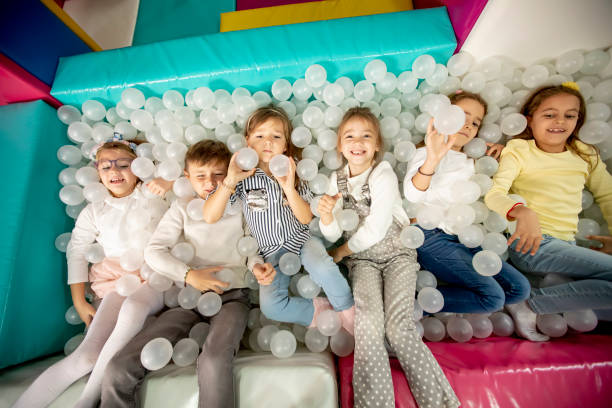 istock Happy little kids in ball pit smiling happily at camera while having fun 1359142934