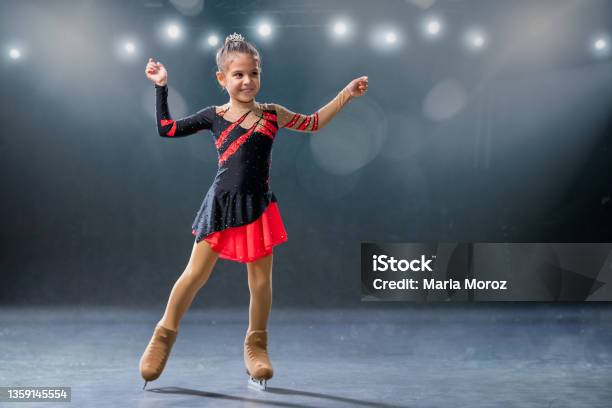 Little Skater Rides On Rings In Red And Black Dress On Ice Arena Stock Photo - Download Image Now