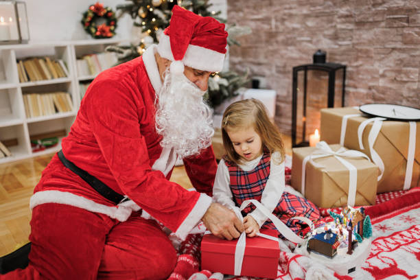 istock Grandfather opens presents with a little girl 1359148376