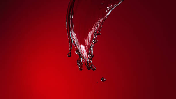 istock Colorful image of wine splash isolated over dark red background 1359148559
