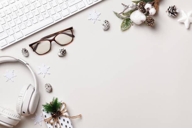 istock Christmas desktop. Keyboard glasses gift headphones on the gray table. Flat lay top view 1359149367