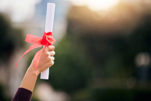 Cropped shot of an unrecognizable young female student celebrating on graduation day The best way to predict the future is to create it diploma stock pictures, royalty-free photos & images