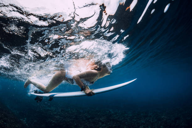 istock Surfer with surfboard dive underwater with ocean wave. 1359153008