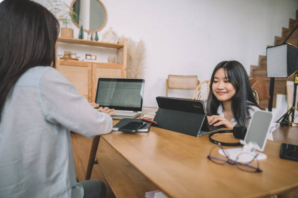 istock Two cheerful Asian women working in home office 1359154681
