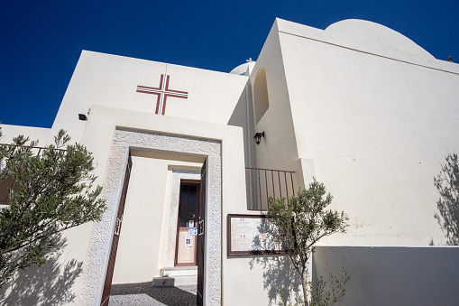 John The Baptist Church in Firá on Santorini in South Aegean Islands, Greece, with identifiable labels and writing in the background