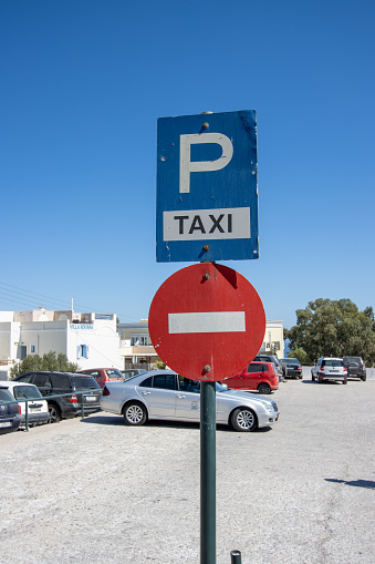 Taxi Rank Sign in Firá on Santorini in South Aegean Islands, Greece, with cars in the background.