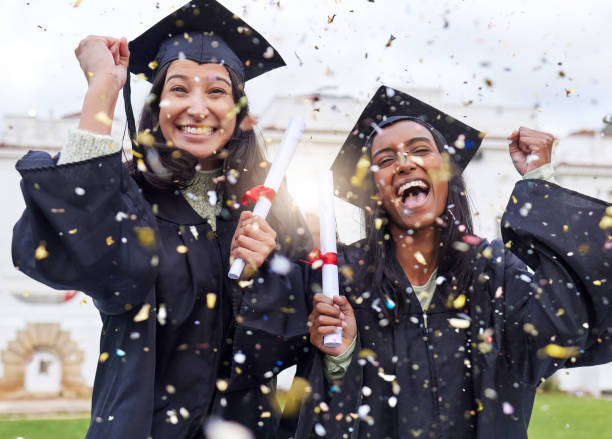 졸업당일을 축하하는 매력적인 젊은 여학생 두 명의 자른 초상화 - graduate student 뉴스 사진 이미지