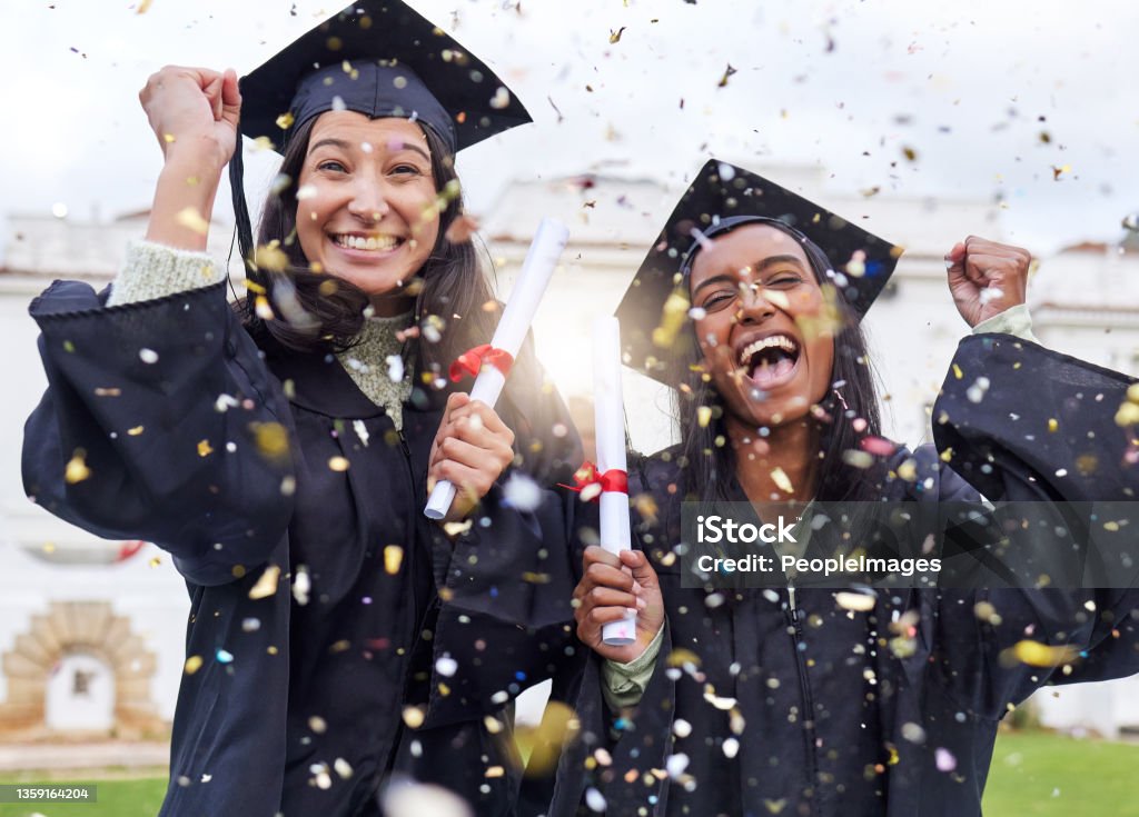Cropped portrait of two attractive young female students celebrating on graduation day Queue the celebrations Graduation Stock Photo