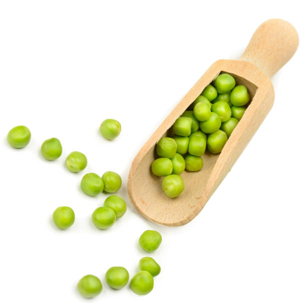 istock Green peas in a wooden duck isolated on a white . 1359165341