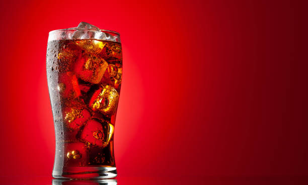 Cola with ice Cola with ice. Fresh cold sweet drink with ice cubes. Over red background with copy space cola photos stock pictures, royalty-free photos & images