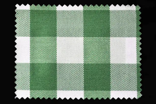 Photo of Green and white checkered fabric sample isolated on black background