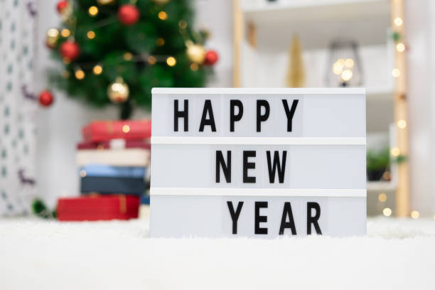 istock Happy New Year Lightbox on a fluffy white carpet with Christmas decorations on the background 1359170789