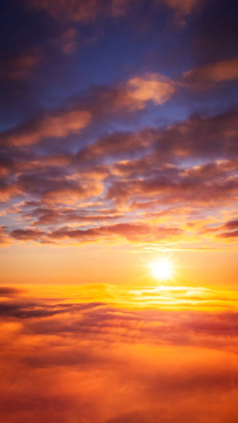 istock Vertical 9:16 photo of setting sun above the clouds 1359174883