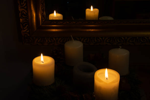 Burning candles in the dark reflected in a mirror