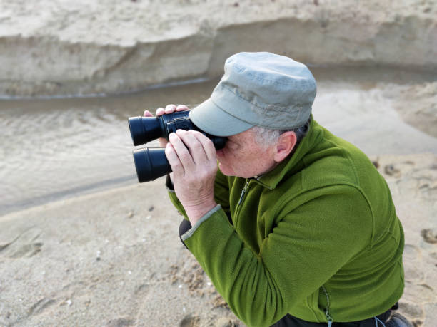 istock adult man looking through binoculars in the desert 1359175840