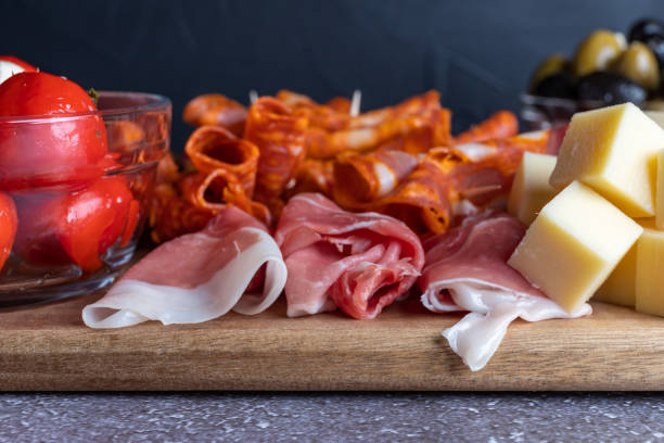 tagliere con prosciutto, salame, formaggio, cracker e olive su una tavola di legno. - inlaid foto e immagini stock