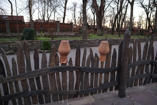 village fence with clay jugs close-up on the background. High quality photo
