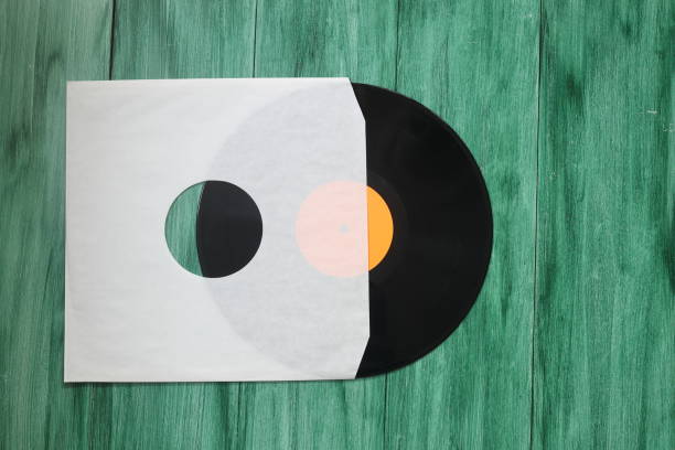 istock Aged White paper cover and vinyl LP record isolated on rusty background 1359186036