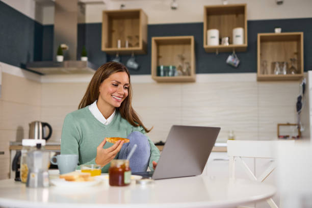 istock Young woman doing a video call on her laptop during breakfast 1359186405