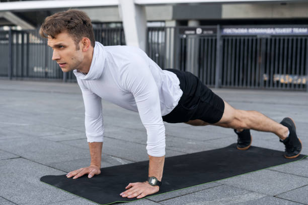 istock Young sportsman training outdoors, standing in plank pose 1359186724