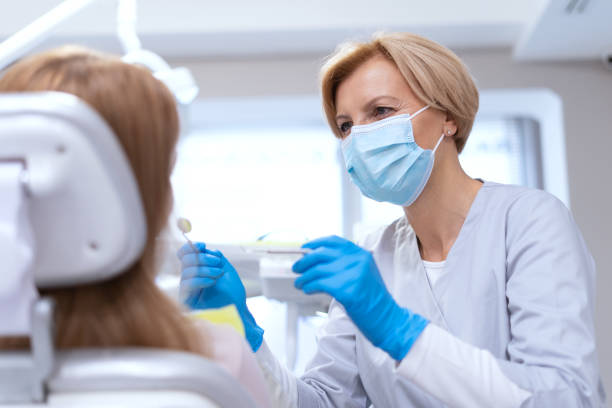 dentista en mascarilla tratando dientes al paciente - scrub brush fotografías e imágenes de stock