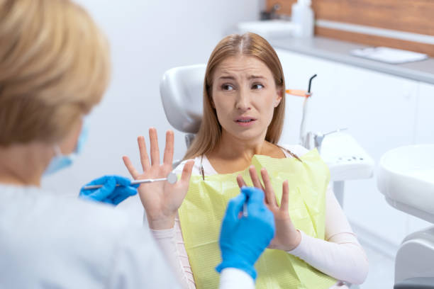 istock Funky woman refusing of teeth treatment during dentist visit 1359187596