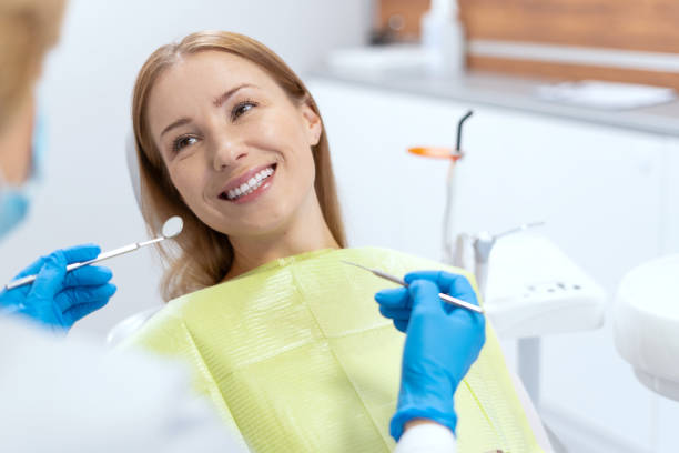 donna sorridente all'appuntamento dal dentista durante la procedura di sbiancamento dei denti - scrub brush immagine foto e immagini stock