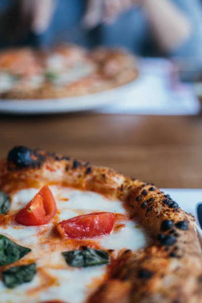 istock Woman eating pizza at cafe 1359189159