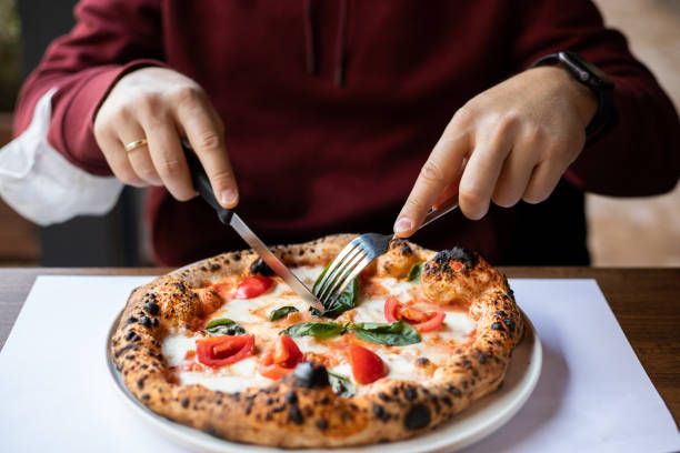 istock Men eating pizza at cafe 1359189590