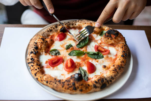 istock Men eating pizza at cafe 1359189674