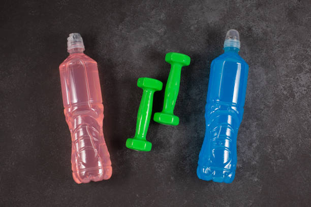istock ENERGY DRINK. Bottles with different flavors and dumbbells on a dark background. 1359193305