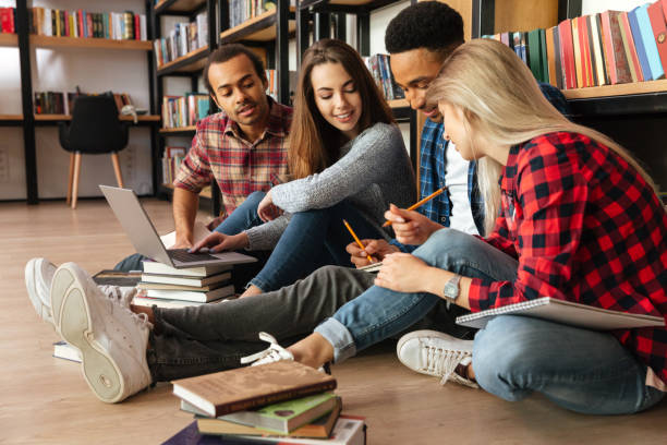 istock Young concentrated students sitting in library on floor 1359193571