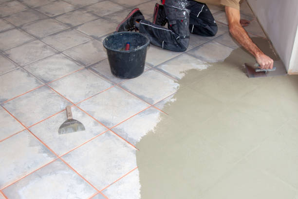 Construction worker leveling compound with putty knife. Renovation, floor leveling screed, mass distribution. stock photo