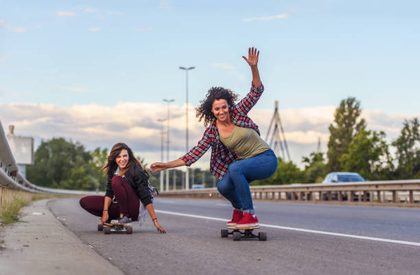 istock Skateboard girls riding longboards down the road 1359193921