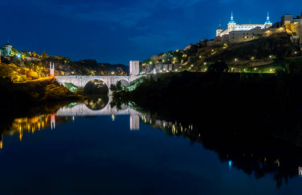 istock The Toledo Spain Alcantara Bridge Reflectd on the Tagus River at Night 1359194776