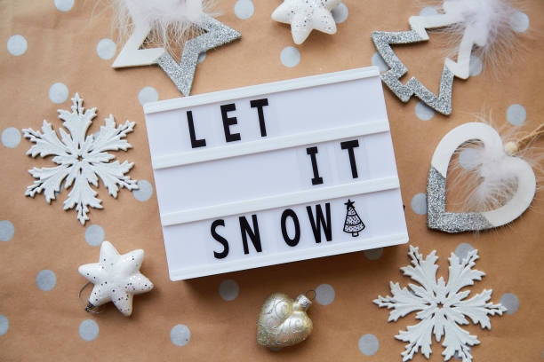 istock Let it snow text around Christmas ornaments. Christmas decorations on dot basic beige and golden background. Christmas mood 1359198866