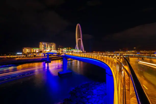 Dubai, United Arab Emirates, December 4th 2021: Long exposure shot of Bluewaters Island, it's access bridge, the restaurants at the waterfront, the casino and the world's largest observation wheel.