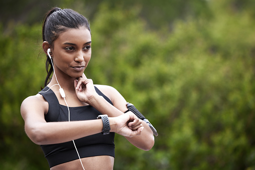 Foto de una joven deportista que se controla el pulso mientras hace ejercicio al aire libre photo