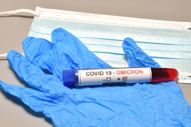 Blood tube for test detection of virus Covid-19 Omicron Variant with positive result and protection masks and gloves. Concept of protection for new variant Covid 19  Omicron. stock photo