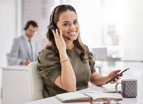 istock Portrait of a young call centre agent using a cellphone while working in an office 1359208140