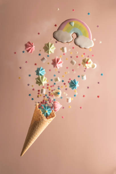 istock Ice cream cone with multicolored meringues, marshmallows and star-shaped sweets on a pink background. Concept for Happy Valentine's Day, Birthday. Party, sweet fireworks. Levitation. Vertical position 1359208479