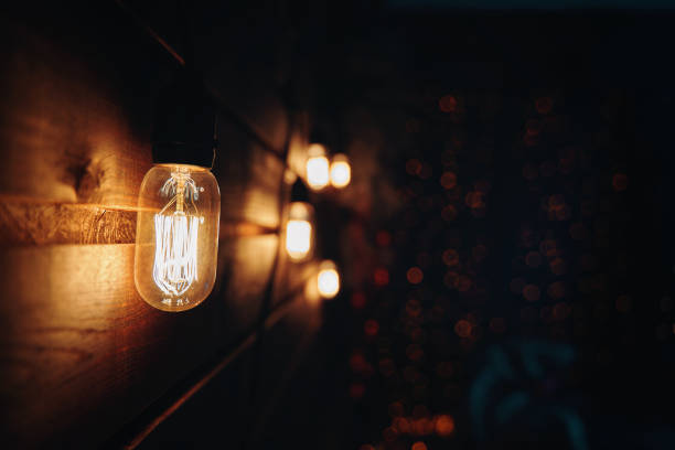 istock Wooden wall with Edison type bulb and blurred background. 1359210561