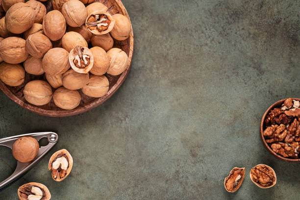 istock Top table view with walnuts in shell on wooden tray 1359211375