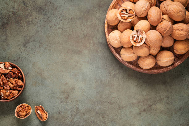istock Walnuts in shell on wooden tray 1359211931