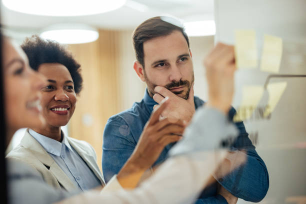 istock Confident group of employees, using the new notice board for the messages. 1359212059
