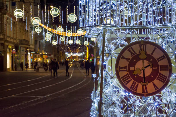 beautiful christmas decorations with famous clock tower on herrengasse street, at night, in the city center of graz, steiermark, austria. long exposure for the movement - graz austria clock tower styria imagens e fotografias de stock