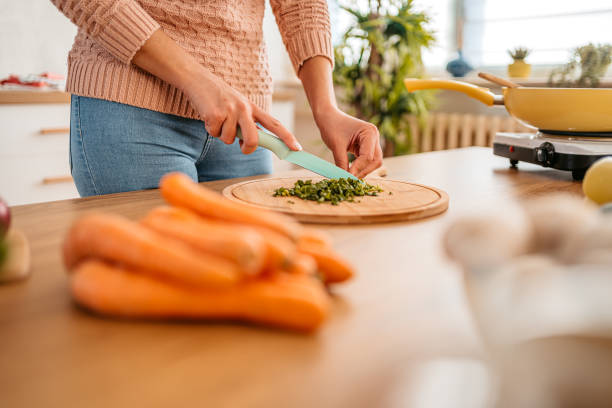 istock Woman cutting spinach on cutting board 1359213369