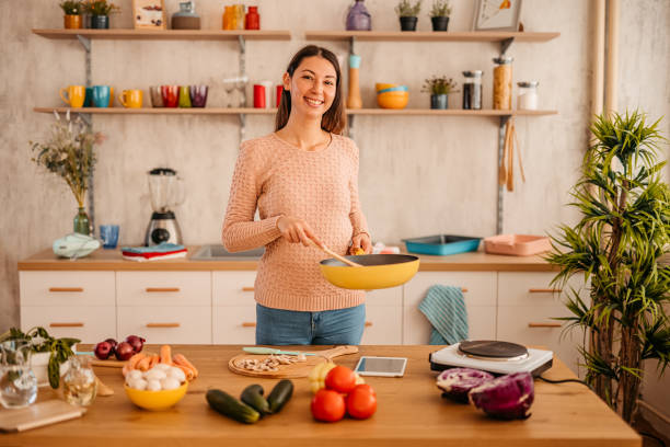 istock Happy woman preparing a dish at home 1359213802