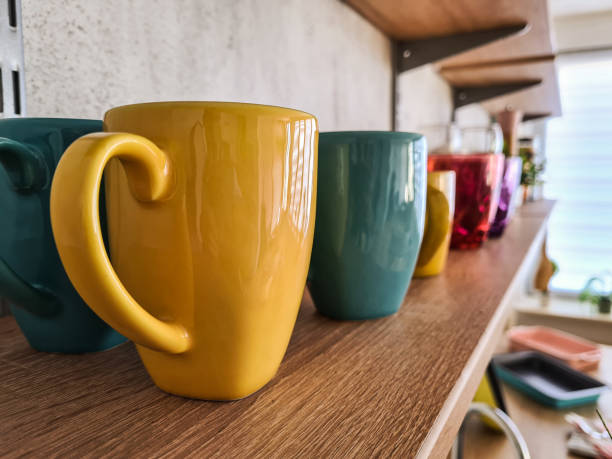 istock Colorful ceramic coffee mugs on shelf 1359213922