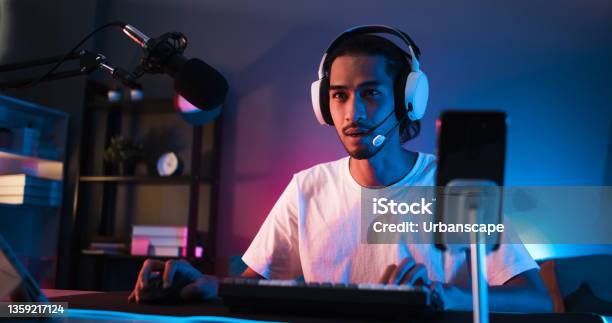 Young Confident Asian Man Playing Online Computer Video Game Colorful Lighting Broadcast Streaming Live At Home Gamer Lifestyle Esport Online Gaming Technology Concept Stock Photo - Download Image Now